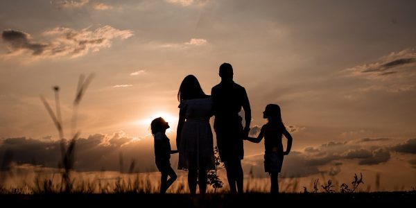 a family standing in a field at sunset