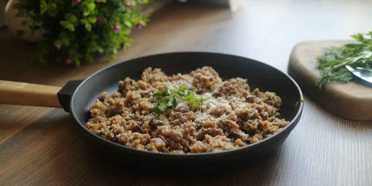 Tasty minced meat dish garnished with herbs in a black skillet, perfect for a delicious homemade meal.