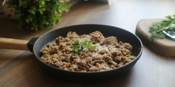 Tasty minced meat dish garnished with herbs in a black skillet, perfect for a delicious homemade meal.